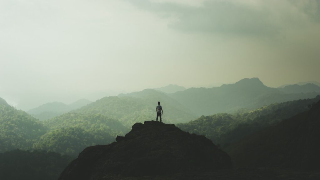 Man standing on foggy mountain top.